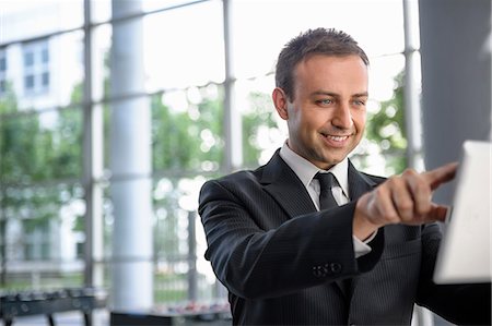 finger - Businessman interacting with digital tablet screen Stock Photo - Premium Royalty-Free, Code: 649-06829821