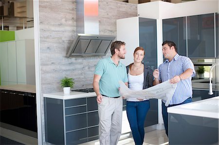 Young couple with salesman in kitchen showroom Stock Photo - Premium Royalty-Free, Code: 649-06844110