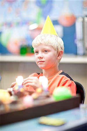 Boy at birthday party wearing party hat Stock Photo - Premium Royalty-Free, Code: 649-06844292