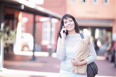 shopping phone - Mid adult woman on cell phone with bread Stock Photo - Premium Royalty-Free, Code: 649-06844328