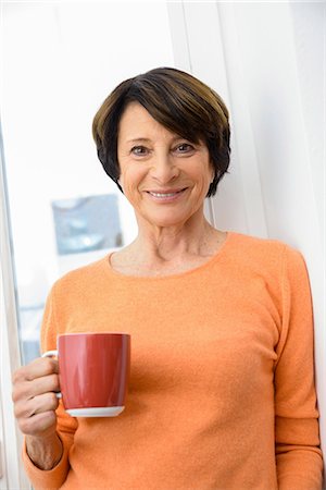 senior coffee alone - Woman holding mug of coffee, smiling Stock Photo - Premium Royalty-Free, Code: 649-06844436