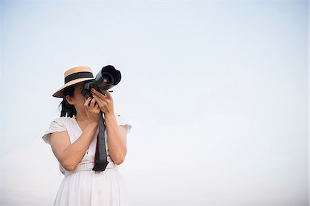 sightseeing people - Woman taking photograph against clear sky Stock Photo - Premium Royalty-Free, Code: 649-06844460