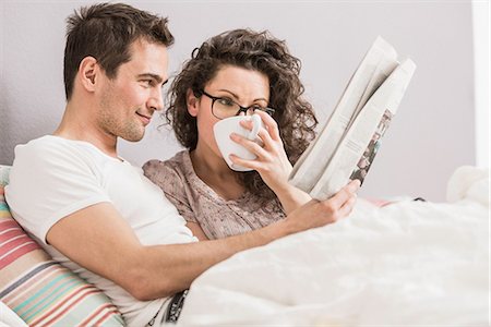 romantic couple bed - Mid adult couple reading newspaper in bed, drinking coffee Photographie de stock - Premium Libres de Droits, Code: 649-06844780