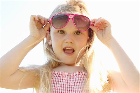 Child putting on sun glasses on hot sunny day Stock Photo - Premium Royalty-Free, Code: 649-06844922