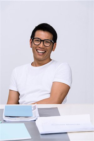 simsearch:649-06845199,k - Young man sitting at desk with paperwork Stock Photo - Premium Royalty-Free, Code: 649-06845192