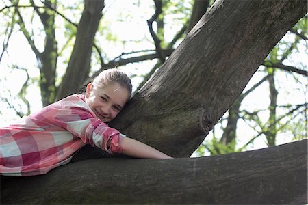 shirt - Portrait of young girl lying on top of tree branch Stock Photo - Premium Royalty-Free, Code: 649-06845236