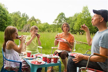 family in a table - Family with two children enjoying birthday cake picnic Stock Photo - Premium Royalty-Free, Code: 649-06845261