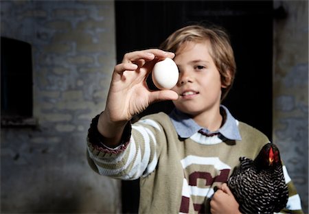 Boy holding egg and chicken outdoors Stock Photo - Premium Royalty-Free, Code: 649-06943786