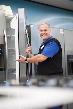 sales associate (male) - Salesman showing fridge in showroom Stock Photo - Premium Royalty-Free, Code: 649-07064066