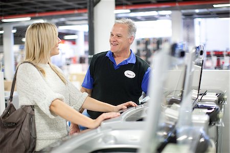 store clerk - Young woman and salesman negotiating in showroom Stock Photo - Premium Royalty-Free, Code: 649-07064087