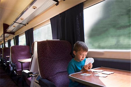 Young boy playing patience on train Stock Photo - Premium Royalty-Free, Code: 649-07064444