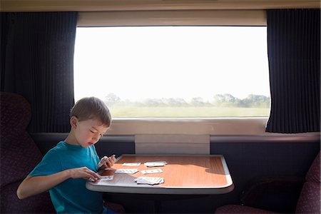simsearch:649-06533379,k - Young boy with playing cards on train Photographie de stock - Premium Libres de Droits, Code: 649-07064443