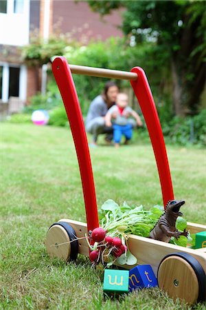 dinosaurs toy kids - Mother and child with push cart and toys in garden Stock Photo - Premium Royalty-Free, Code: 649-07064482