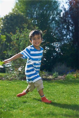 simsearch:614-07031875,k - Boy playing with bubbles in garden Foto de stock - Sin royalties Premium, Código: 649-07064781