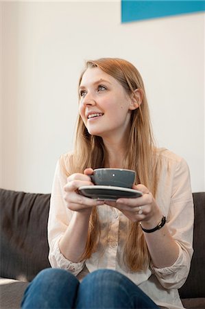 Portrait of young woman holding coffee cup in cafe Stock Photo - Premium Royalty-Free, Code: 649-07064880