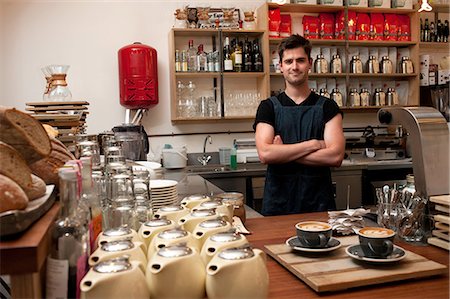 Portrait of young man behind kitchen counter in cafe Photographie de stock - Premium Libres de Droits, Code: 649-07064890