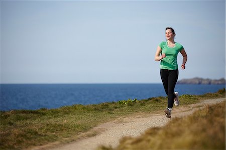 fit young woman - Young woman running along coastal path Stock Photo - Premium Royalty-Free, Code: 649-07063008