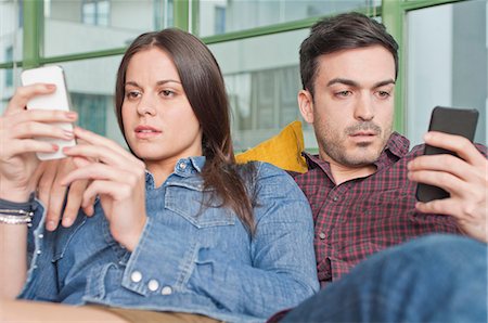 denim shirt - Young couple at home using mobile phones Foto de stock - Sin royalties Premium, Código: 649-07063158