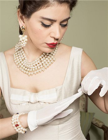elegant sophisticated women - Portrait of woman in vintage clothes removing glove Stock Photo - Premium Royalty-Free, Code: 649-07063573