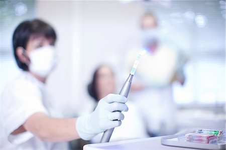 dentist with patient in exam room - Close up of dentists hand holding ultraviolet light Stock Photo - Premium Royalty-Free, Code: 649-07063608