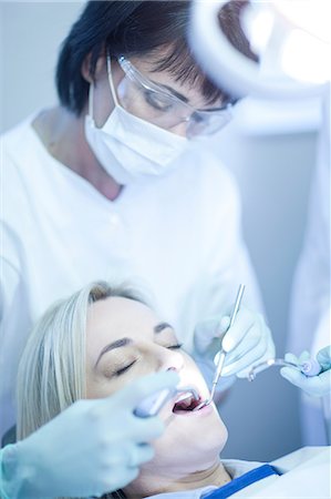 Female dentist examining patients teeth Stock Photo - Premium Royalty-Free, Code: 649-07063602