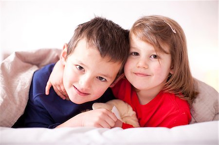 sister brother hugging two - Two young children hugging under duvet Stock Photo - Premium Royalty-Free, Code: 649-07063621