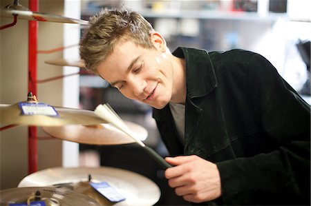 simsearch:614-06719795,k - Young male trying drum kit in music store Stock Photo - Premium Royalty-Free, Code: 649-07063807