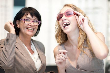 Two women laughing whilst trying on eyeglasses Stock Photo - Premium Royalty-Free, Code: 649-07063801