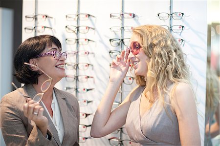 simsearch:649-07063763,k - Two women trying on eyeglasses in opticians shop Stock Photo - Premium Royalty-Free, Code: 649-07063802