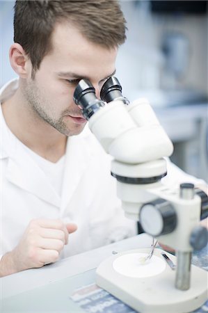 dental work - Dental technician looking through microscope at false tooth Stock Photo - Premium Royalty-Free, Code: 649-07063859