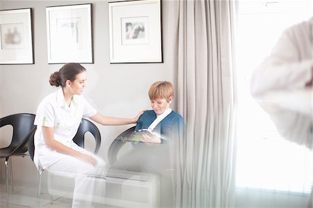 pediatric - Nurse chatting to young patient in hospital reception Stock Photo - Premium Royalty-Free, Code: 649-07063868