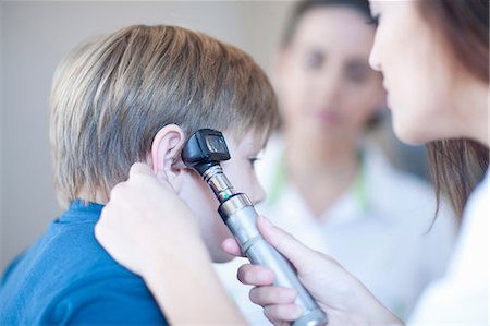 doctor consult patient male - Doctor checking boys ear Stock Photo - Premium Royalty-Free, Code: 649-07063880