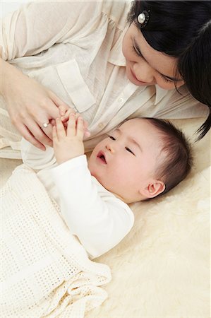 Mother and baby boy lying together holding hands Stock Photo - Premium Royalty-Free, Code: 649-07118173
