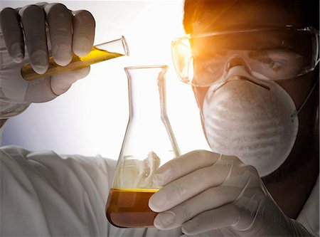 Close up of scientist pouring liquid into flask Stock Photo - Premium Royalty-Free, Code: 649-07118199
