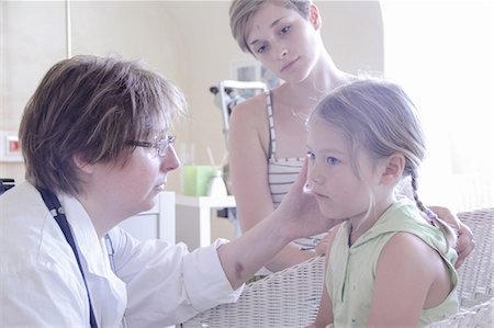 Doctor examining girl, mother watching Stock Photo - Premium Royalty-Free, Code: 649-07118277