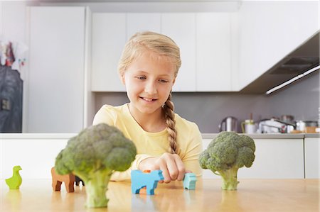 Girl playing with toy animals around broccoli Stock Photo - Premium Royalty-Free, Code: 649-07118300