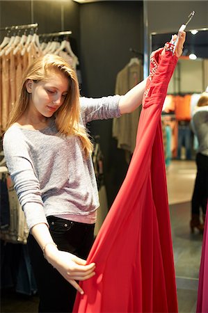 dress shopping - Young woman with red dress in fitting room Stock Photo - Premium Royalty-Free, Code: 649-07118413