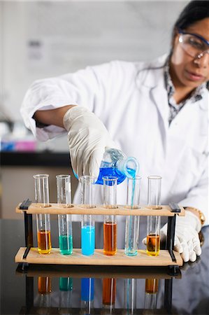 Chemistry teacher pouring chemicals into test tubes Stock Photo - Premium Royalty-Free, Code: 649-07118443
