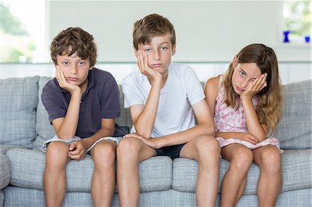 Brothers and sister on sofa looking bored Photographie de stock - Premium Libres de Droits, Code: 649-07118649