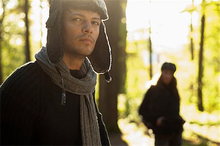 simsearch:649-07279678,k - Portrait of mid adult man wearing hat and scarf, woman in background Stock Photo - Premium Royalty-Free, Code: 649-07118783