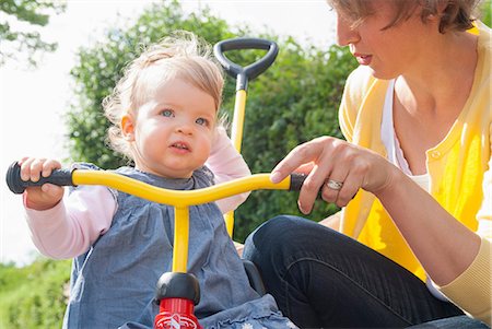 Mother with daughter on tricycle Stock Photo - Premium Royalty-Free, Code: 649-07118966