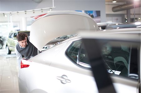 Mid adult man checking car boot in car showroom Photographie de stock - Premium Libres de Droits, Code: 649-07119136