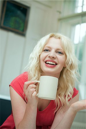 Young woman in conversation, holding a hot drink Stock Photo - Premium Royalty-Free, Code: 649-07238243