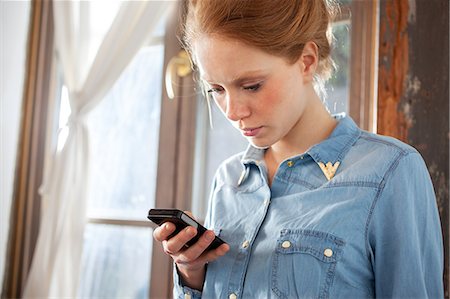 Young woman using smartphone Stock Photo - Premium Royalty-Free, Code: 649-07238479