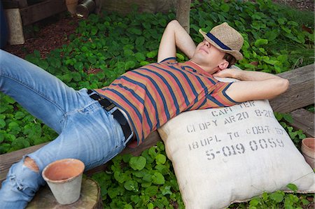 sack - Young man wearing straw hat lying on sack Stock Photo - Premium Royalty-Free, Code: 649-07238545