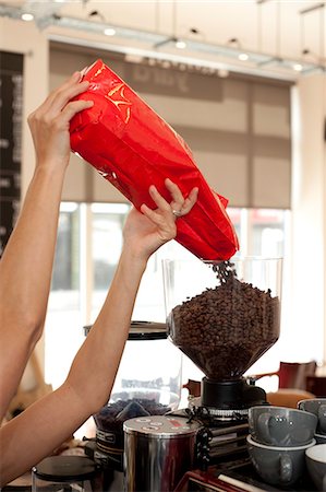 Barista pouring coffee beans into grinder Stock Photo - Premium Royalty-Free, Code: 649-07238684