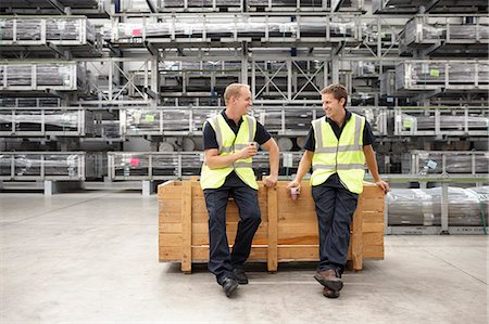 simsearch:649-07239373,k - Two warehouse workers leaning on crate in engineering warehouse Stock Photo - Premium Royalty-Free, Code: 649-07239388
