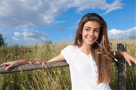 portrait looking away - Teenage girl leaning on wooden fence, Tuscany, Italy Stock Photo - Premium Royalty-Free, Code: 649-07239603