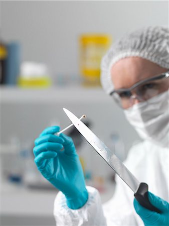 Forensic scientist in laboratory taking DNA evidence with a swab for crime investigation Stock Photo - Premium Royalty-Free, Code: 649-07279842