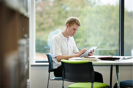 school uniform - Teenage boy using digital tablet in library Stock Photo - Premium Royalty-Free, Code: 649-07280080